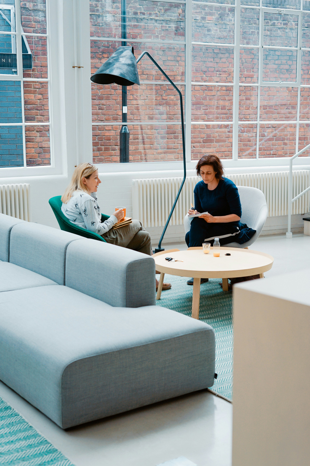 Two people sitting on couches in an office.