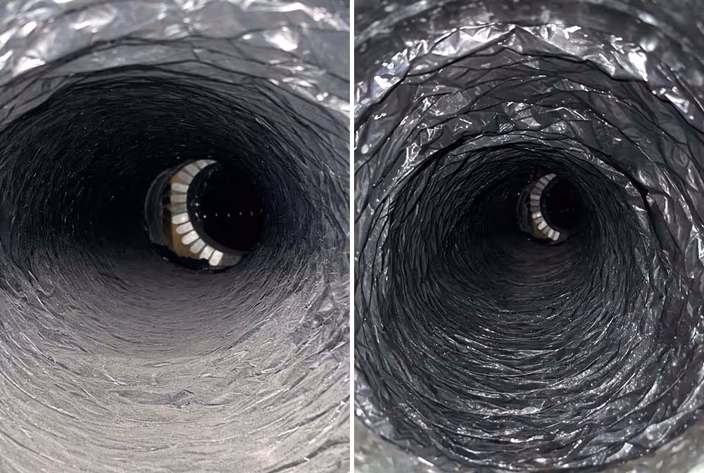 Circular stone fire pit surrounded by light-colored patio pavers with a coiled garden hose on the ground and a black metal fence with trees in the background.