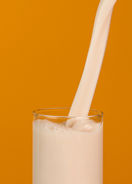 Glass of Alpro milk with orange background