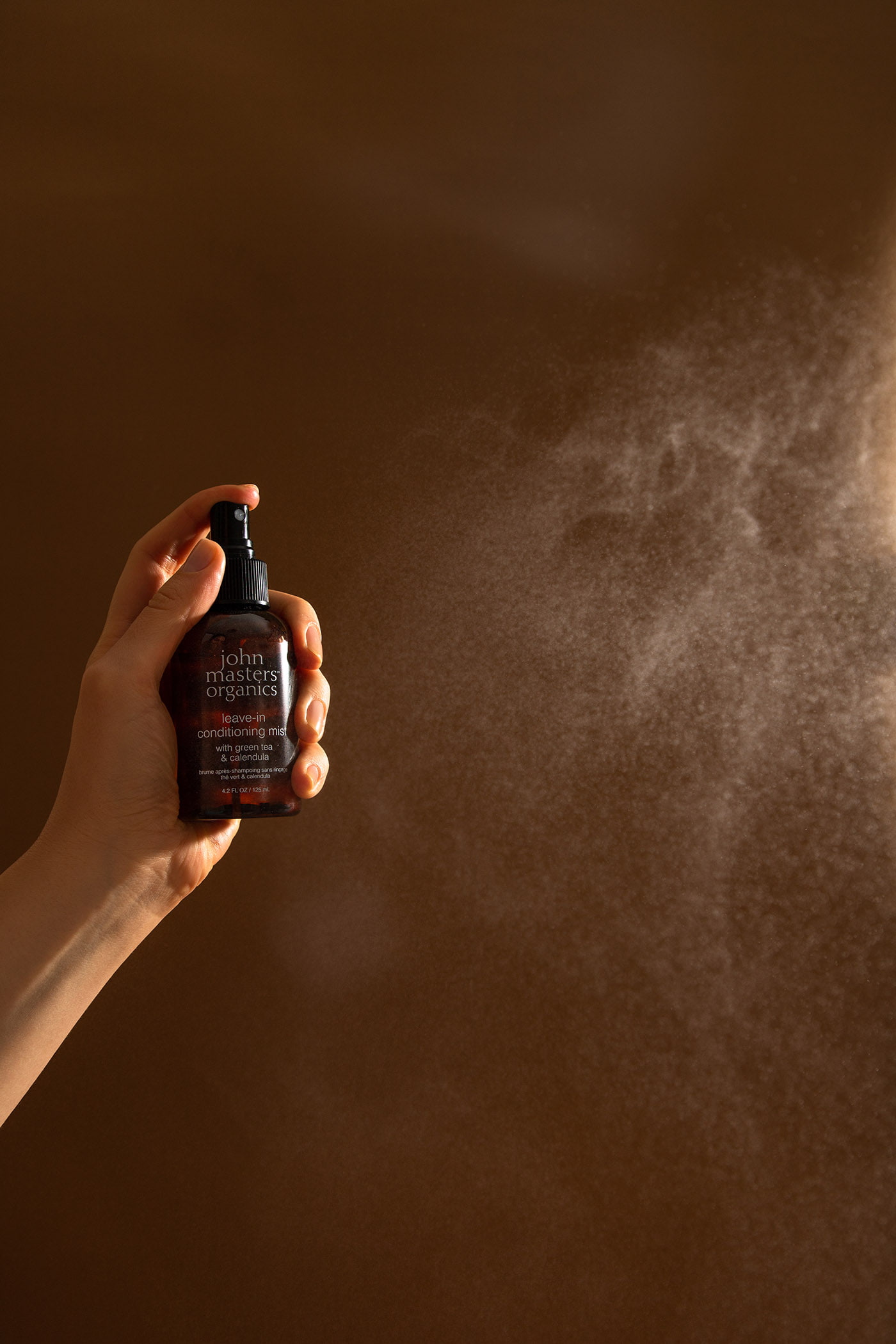John Master spray with brown background