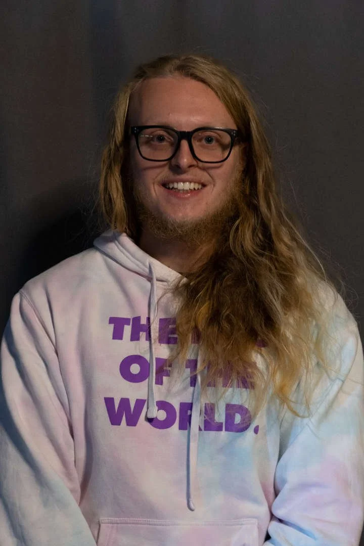 C Swift staff portrait smiling in tie-dye hoodie