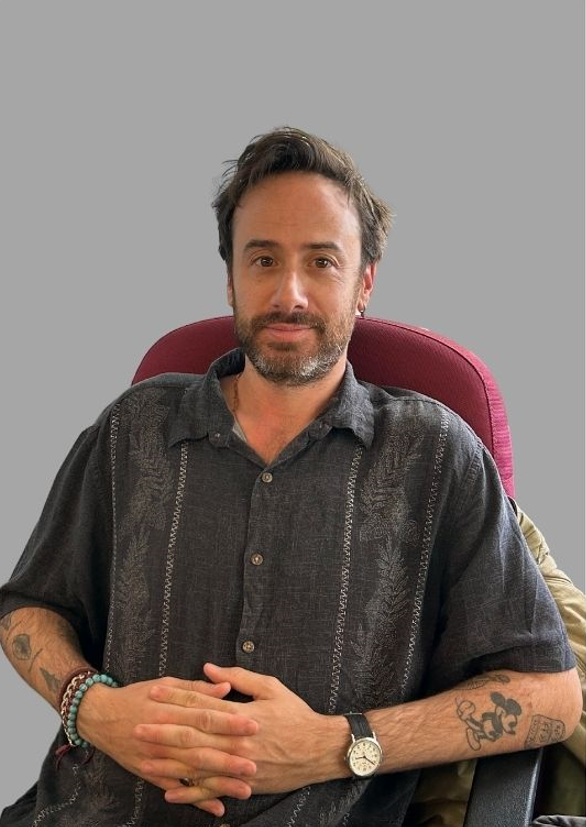 Staff member I. Gould seated in office chair facing camera