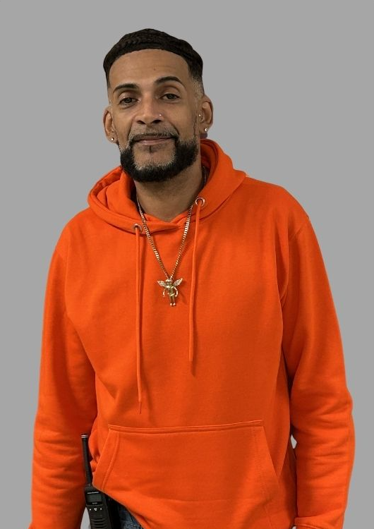 Staff member M. Perez wearing an orange hoodie with radio