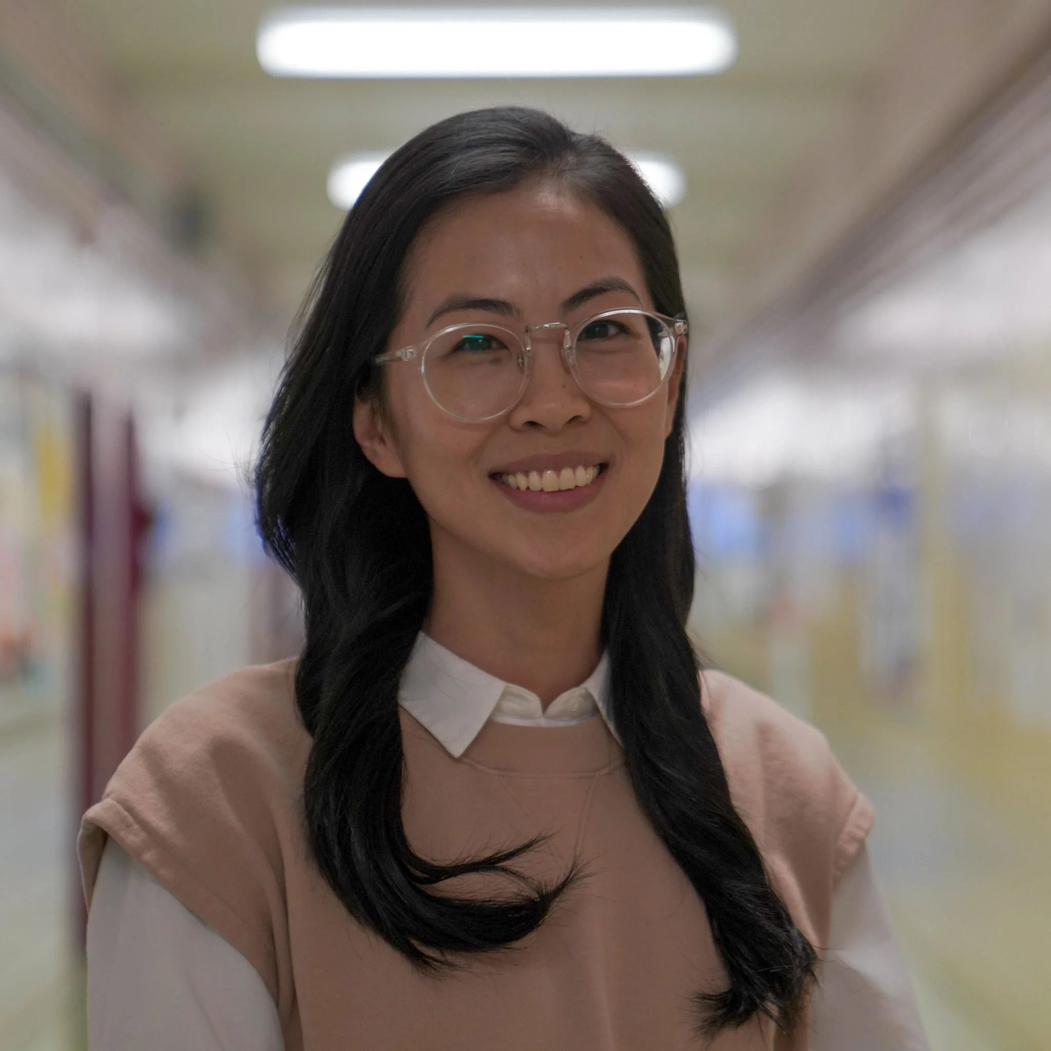 Staff member Bo Young Kim smiling in a school hallway