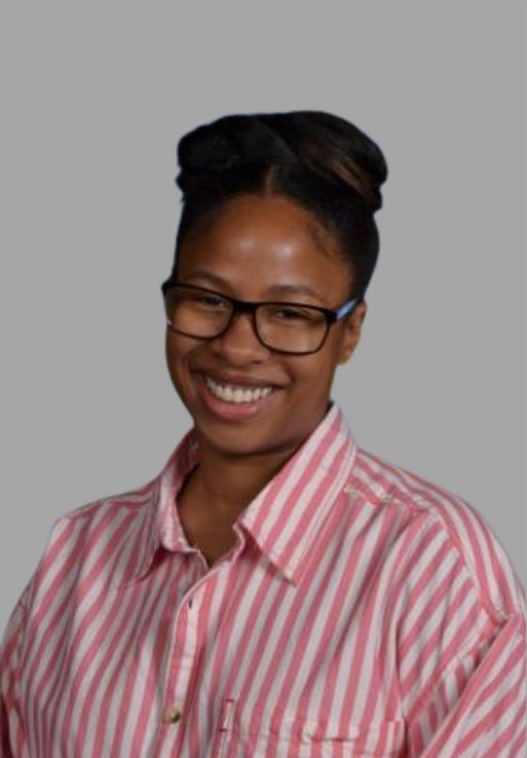 Susanne Sparks smiling staff portrait in striped pink shirt