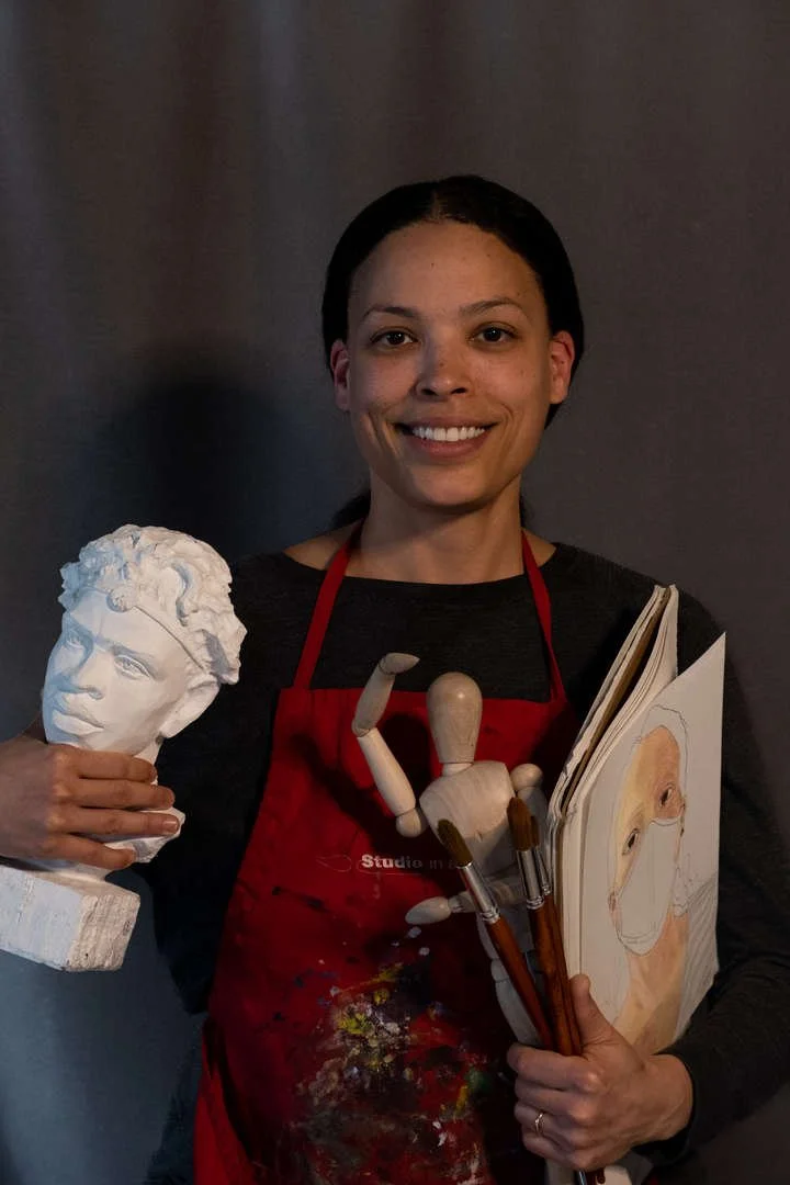 Art teacher holding sculpture brushes sketchbook and figure mannequin