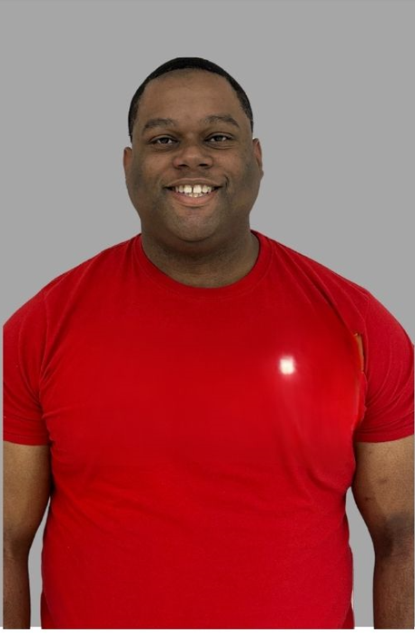 Staff member J Adams smiling in a red shirt