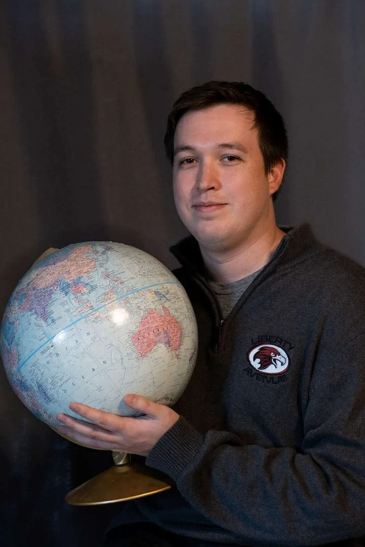 Staff member S Telano holding a world globe