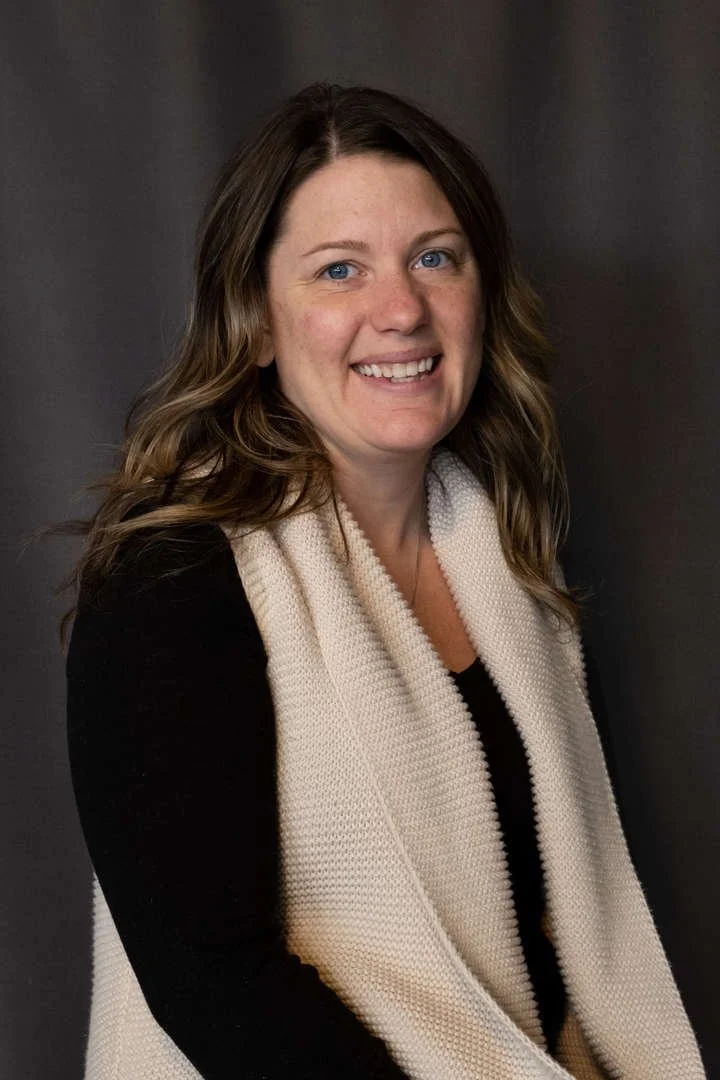Staff portrait of M Esrick smiling in professional headshot