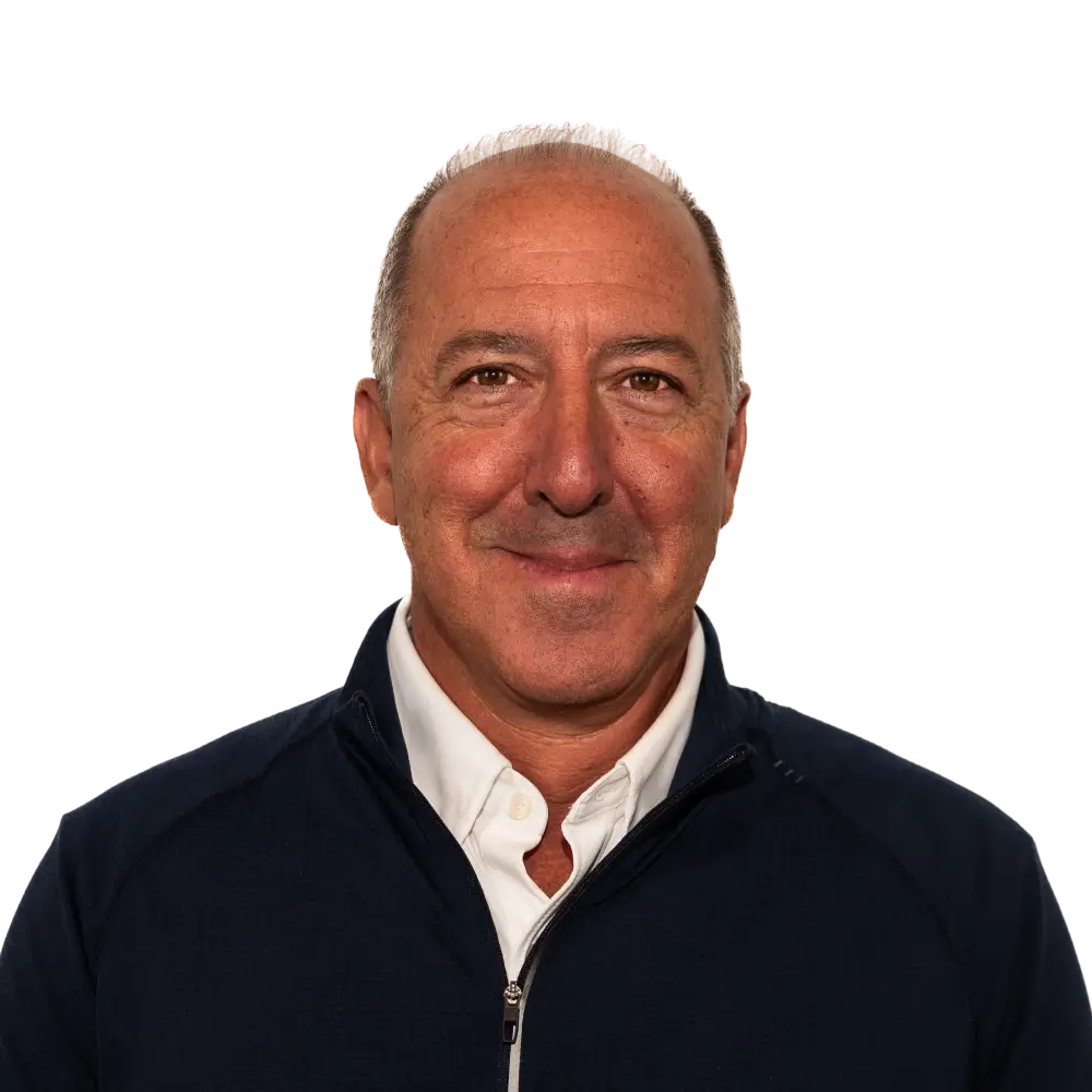 Smiling middle-aged man with short gray hair wearing a white shirt and navy zip-up jacket.