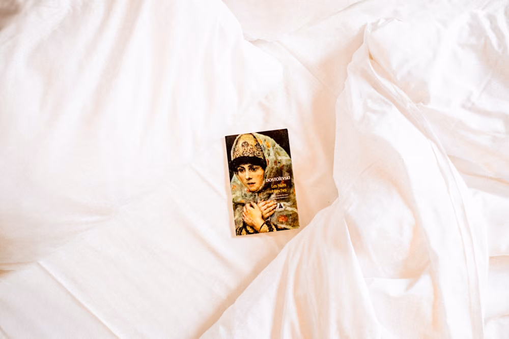 Petite attention de bienvenue déposée sur un lit douillet chez Glintstay, parfait pour un week-end romantique à Toulouse en amoureux.