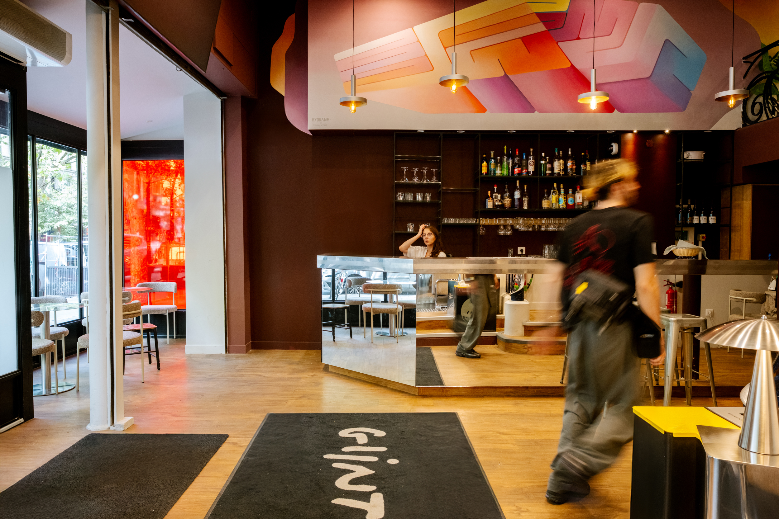 Lobby contemporain de Glint Paris avec bar, espace détente et décoration colorée