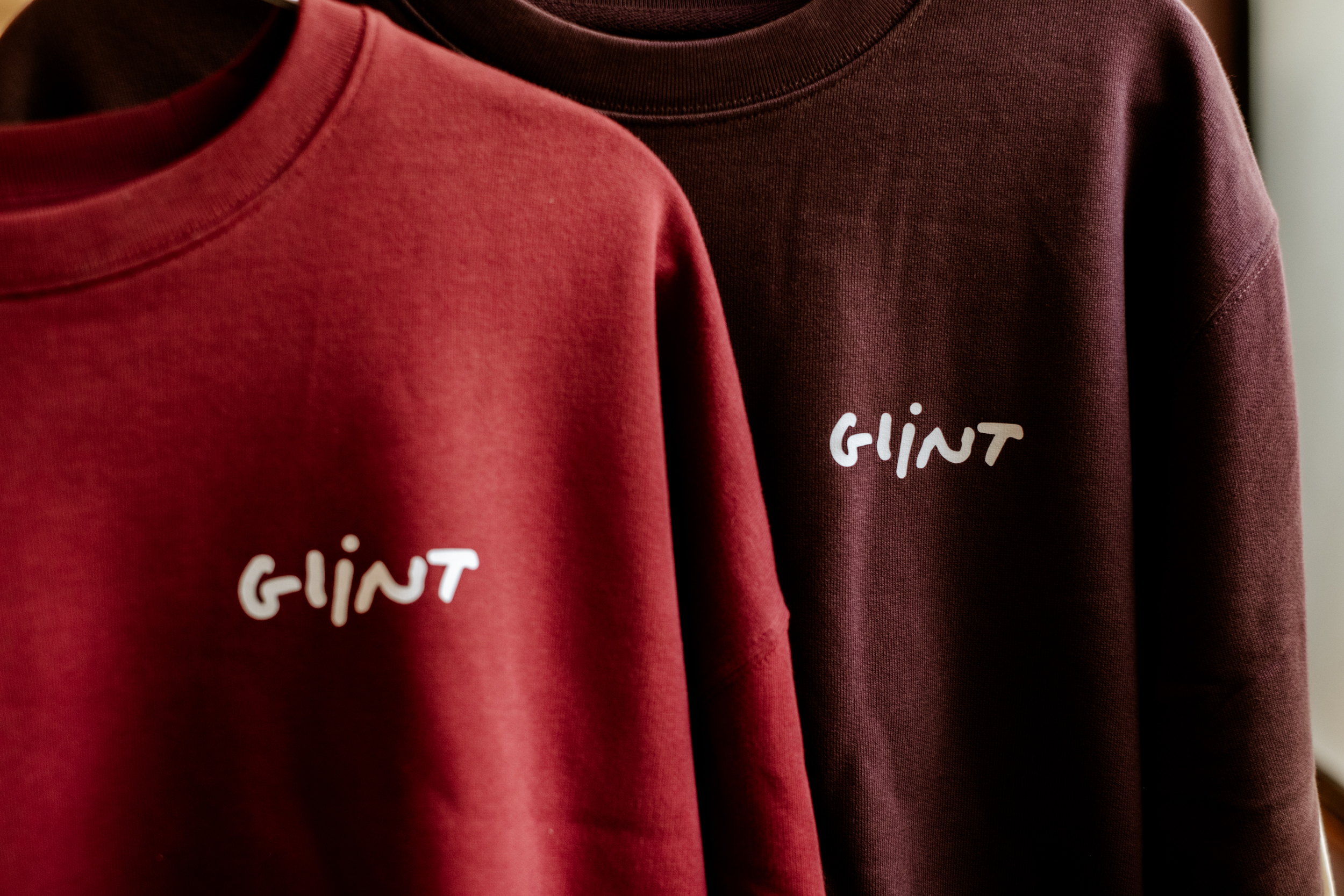 Deux sweat-shirts rouges avec le logo blanc Glint sur la poitrine.