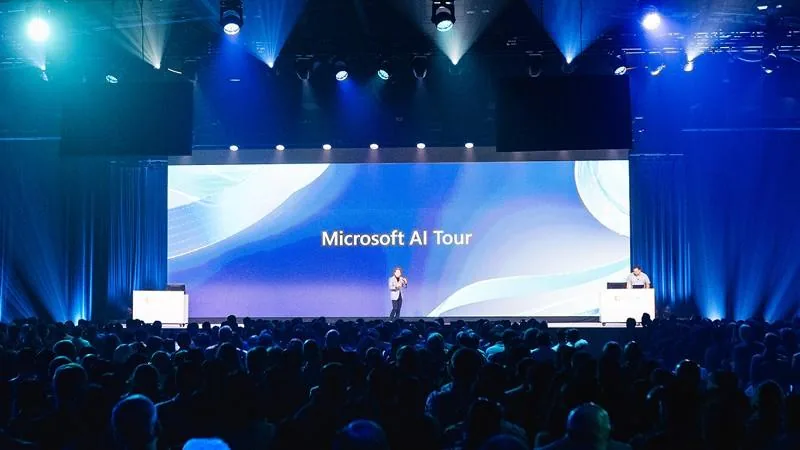 Bühne der Microsoft AI Tour in München mit Redner vor der Leinwand und Publikum im Saal