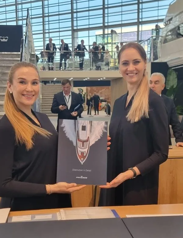 Messehostess von eventas lächelt beim Gästeempfang auf dem Princess-Yachts-Stand auf der BOOT Düsseldorf