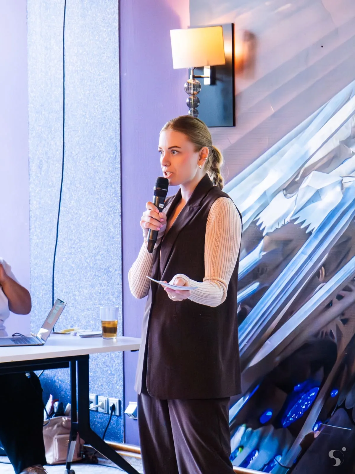 Moderatorin Maja Junginger mit Mikrofon auf der Bühne beim OpenAI Experience Lab
