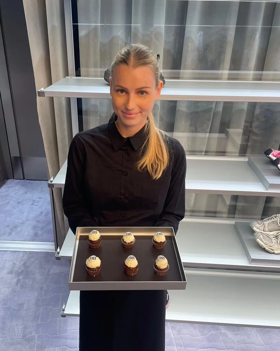 Servicehostess von eventas in schwarzer Dienstkleidung hält ein Tablett mit Cupcakes bei einem BALENCIAGA-Einsatz