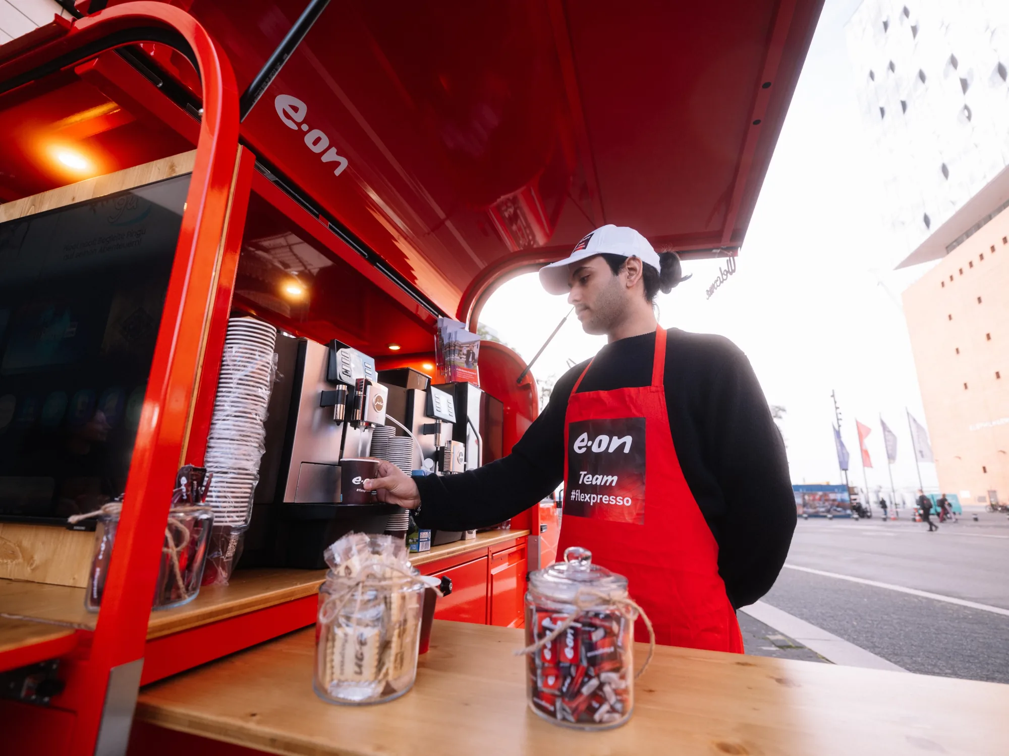 Barista von eventas bereitet an der E.ON Kaffee-Ape einen Kaffee zu, im Hintergrund die Elbphilharmonie