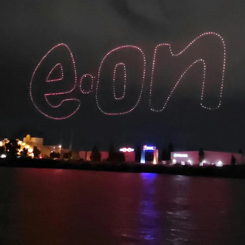 E.ON logo drawn by a drone show in the night sky above the water