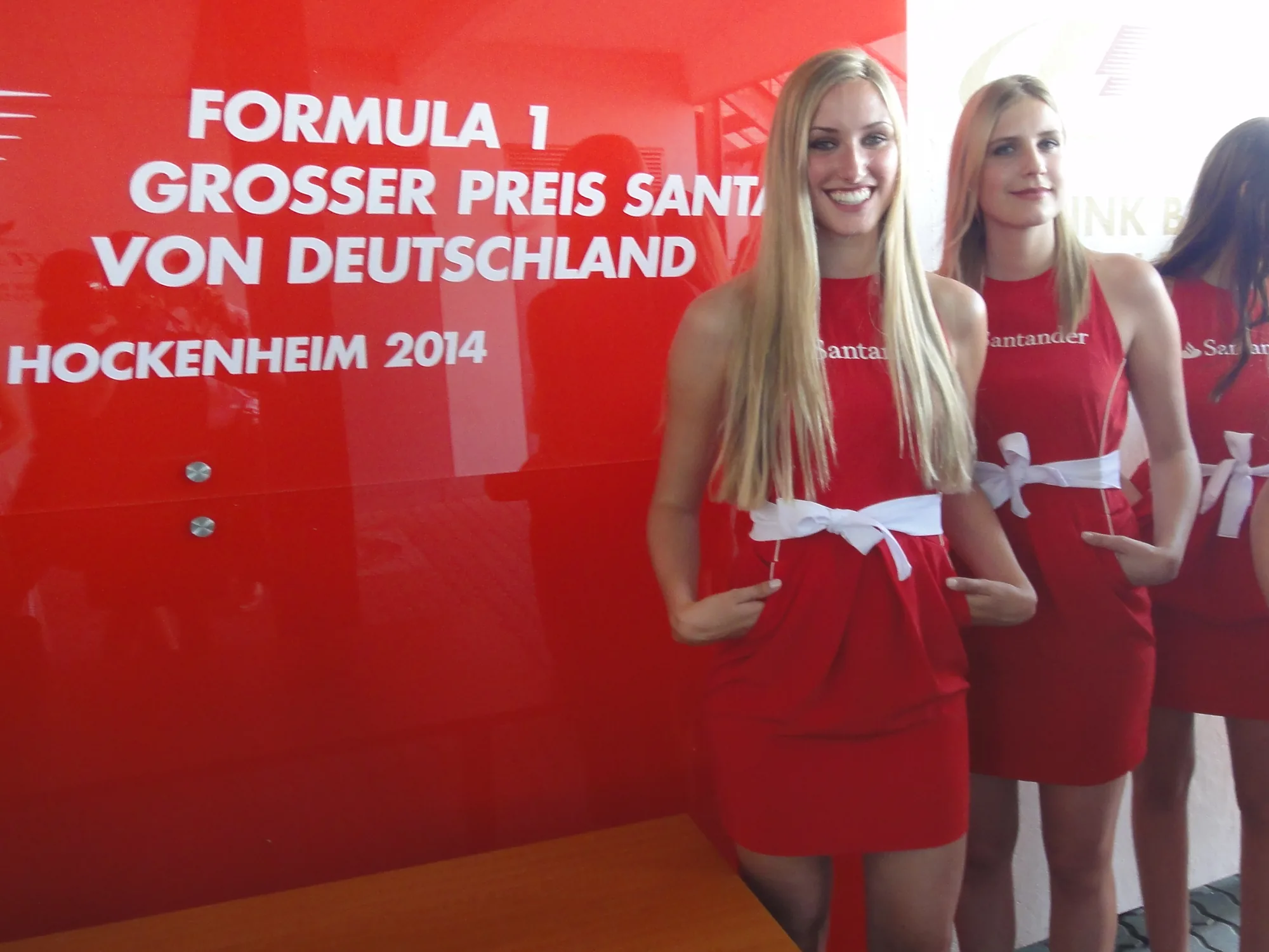 Grid girls in red Santander dresses in front of the Formula 1 Grosser Preis Santander von Deutschland Hockenheim 2014 wall | eventas