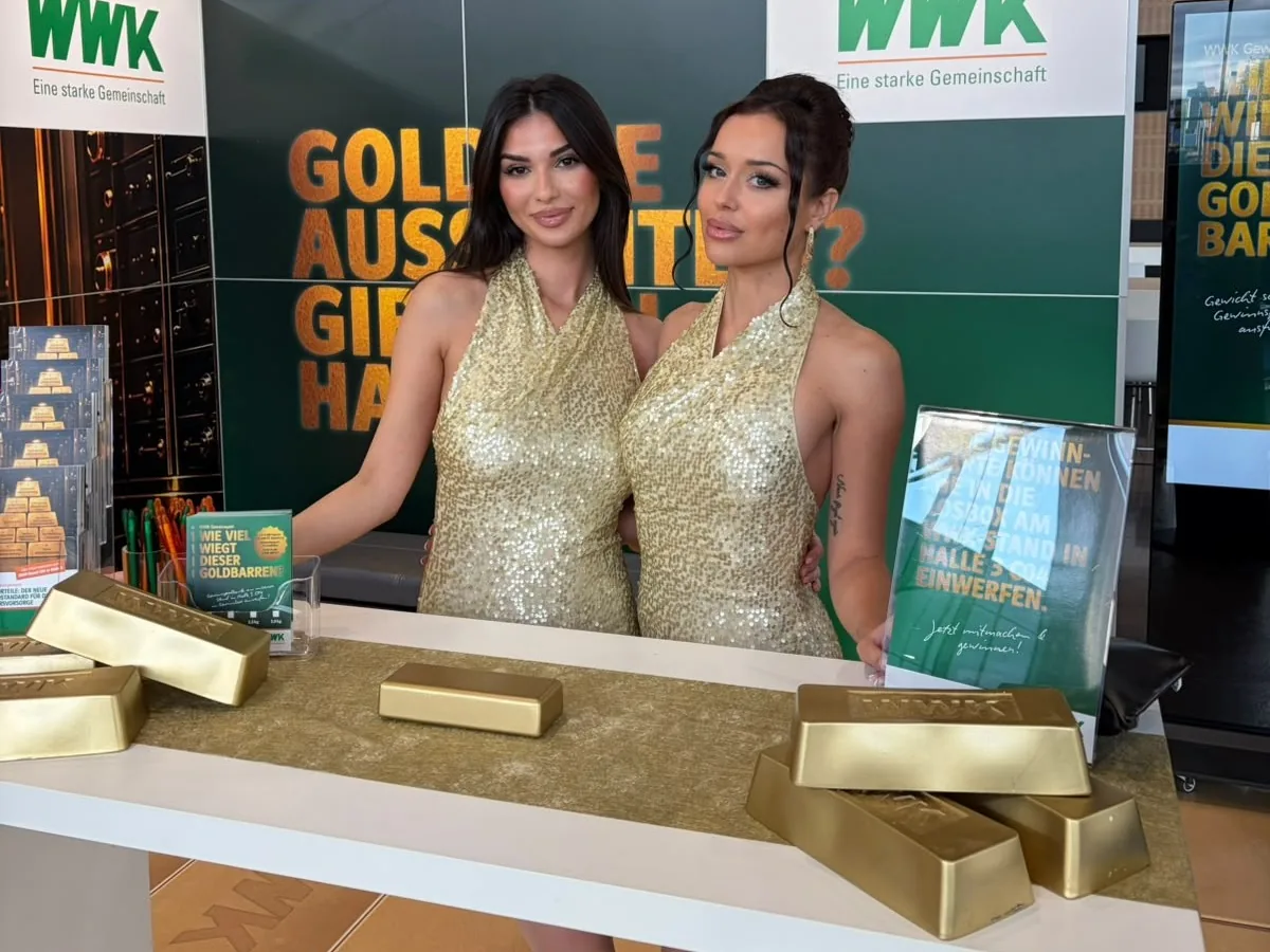 Zwei Promoterinnen in goldenen Pailletten-Kleidern am WWK-Messestand auf der DKM 2026 in Dortmund, davor Goldbarren-Dekoration | eventas