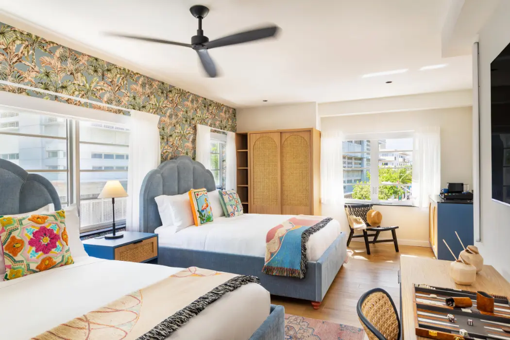 Boutique hotel guest room with two queen beds and contemporary interior design.