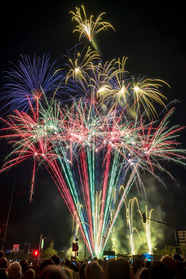 Éclats rouges verts bleus et dorés explosant au-dessus de la foule lors du spectacle pyrotechnique de la Fête Nationale à Strasbourg