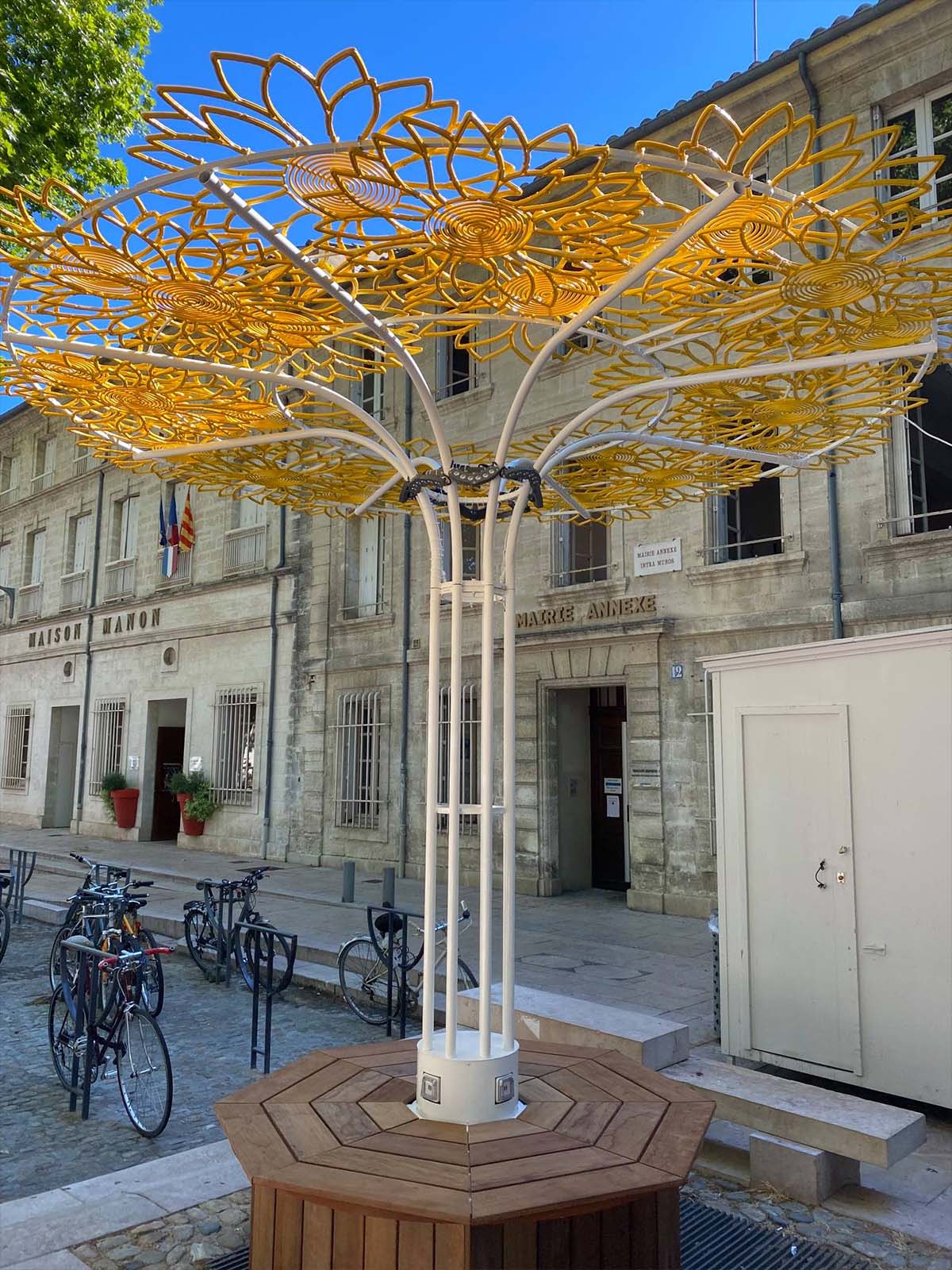 Sculpture métallique en forme d'arbre avec motifs floraux jaunes, installation artistique urbaine extérieure Wagnon Events