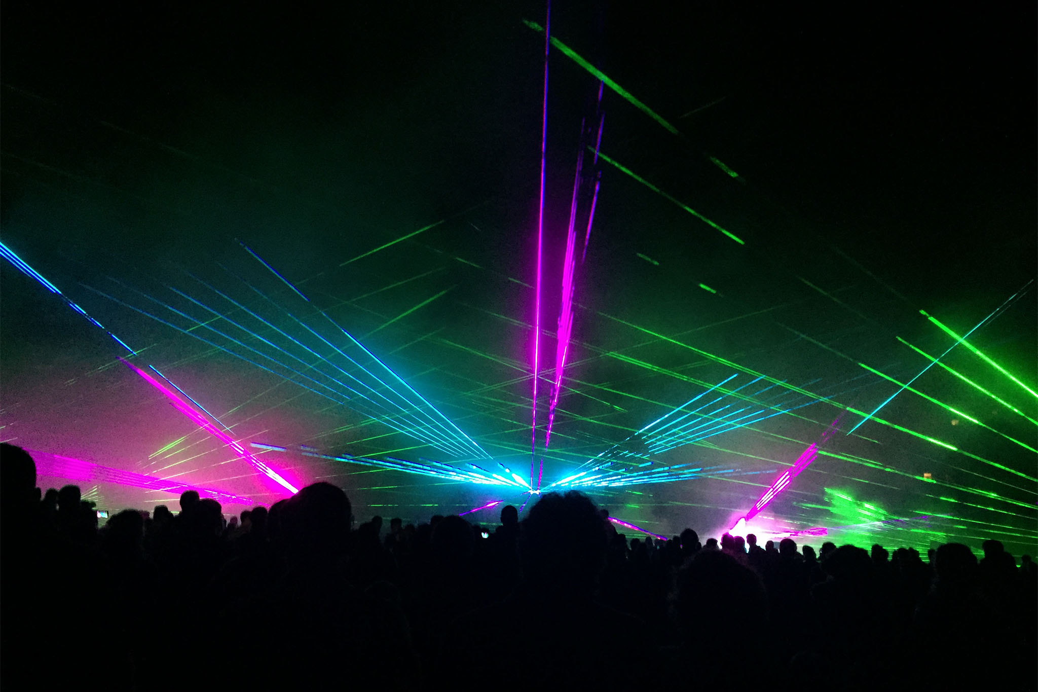 Foule en train de danser sous des faisceaux laser verts bleus et violets lors d'un spectacle nocturne événementiel Wagnon Events