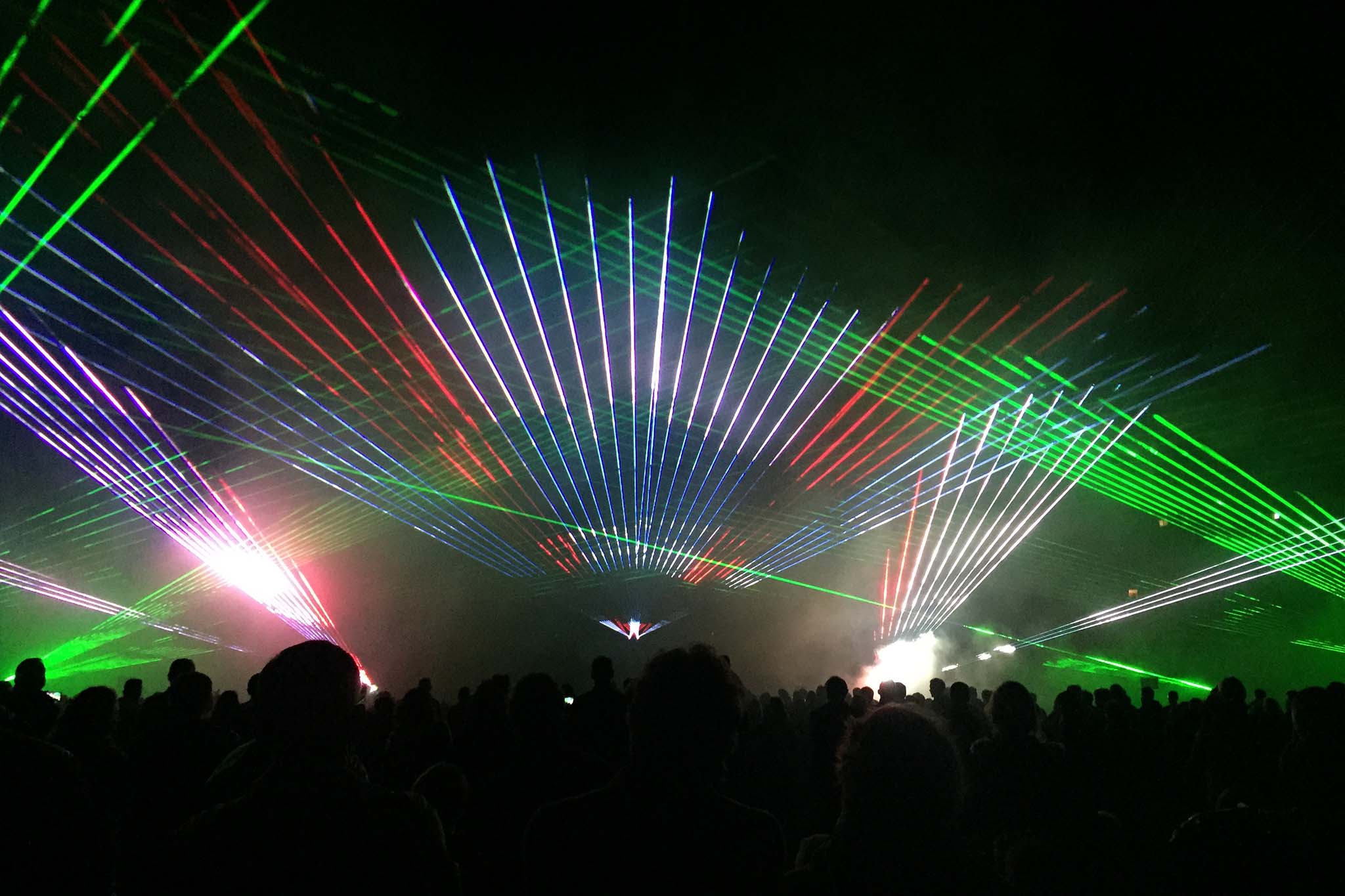 Spectacle laser multicolore vert rouge bleu et blanc illuminant la foule lors des Feux Folies, Wagnon Events