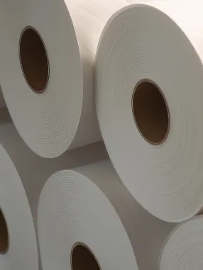 Várias bobinas grandes de papel branco alinhadas lado a lado.