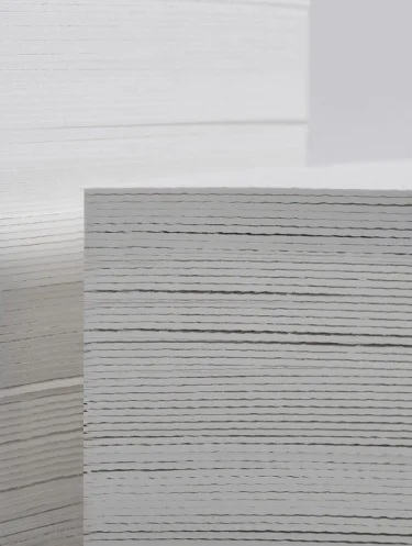Pilha de folhas de papel branco empilhadas em um ambiente claro.