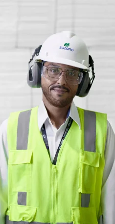 Homem usando colete de segurança amarelo, capacete branco com logo �ڰ�������, protetores auriculares e óculos de segurança.