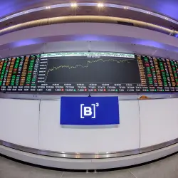 Painel eletrônico com gráficos e números do mercado financeiro na B3, bolsa de valores brasileira.
