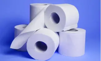 Seis rolos de papel higiênico branco empilhados sobre um fundo azul.