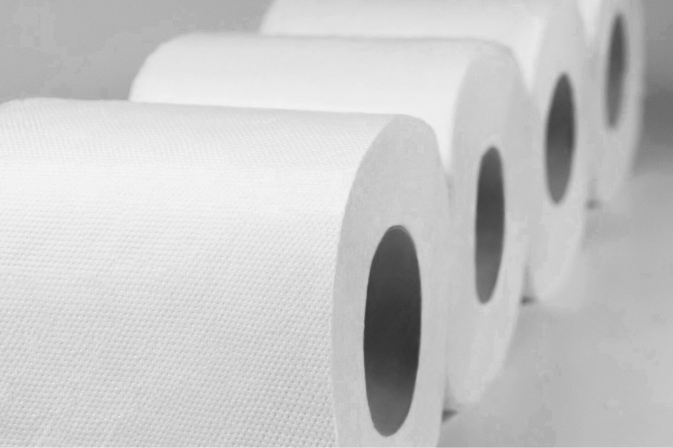 Quatro rolos de papel branco alinhados em sequência, com textura visível na superfície.