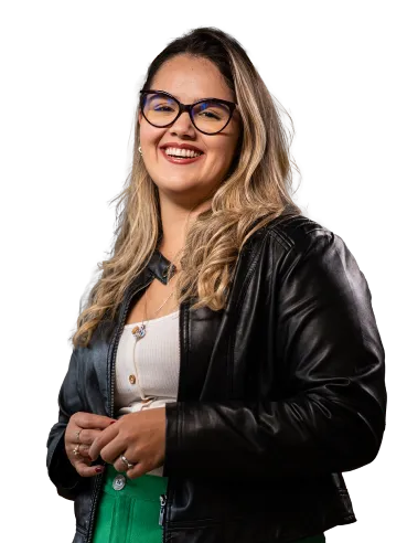 Mulher sorridente usando óculos, jaqueta de couro preta, blusa branca e calça verde.