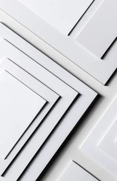 Fechamento próximo de camadas sobrepostas de papel branco criando um padrão geométrico.
