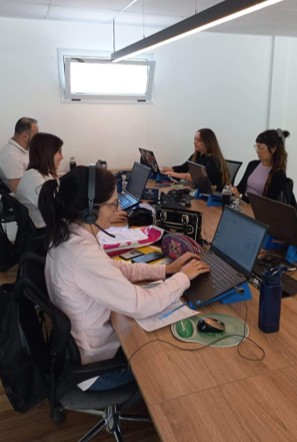 Grupo de pessoas trabalhando em laptops em uma mesa de escritório moderna.