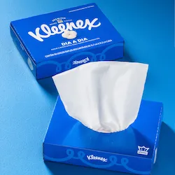 Caixa azul de lenços Kleenex com um lenço branco parcialmente puxado para fora.
