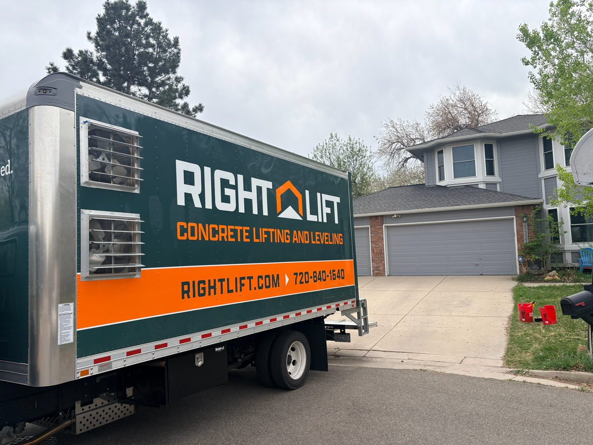 RightLift concrete lifting and leveling truck parked in front of a suburban house with a three-car garage.