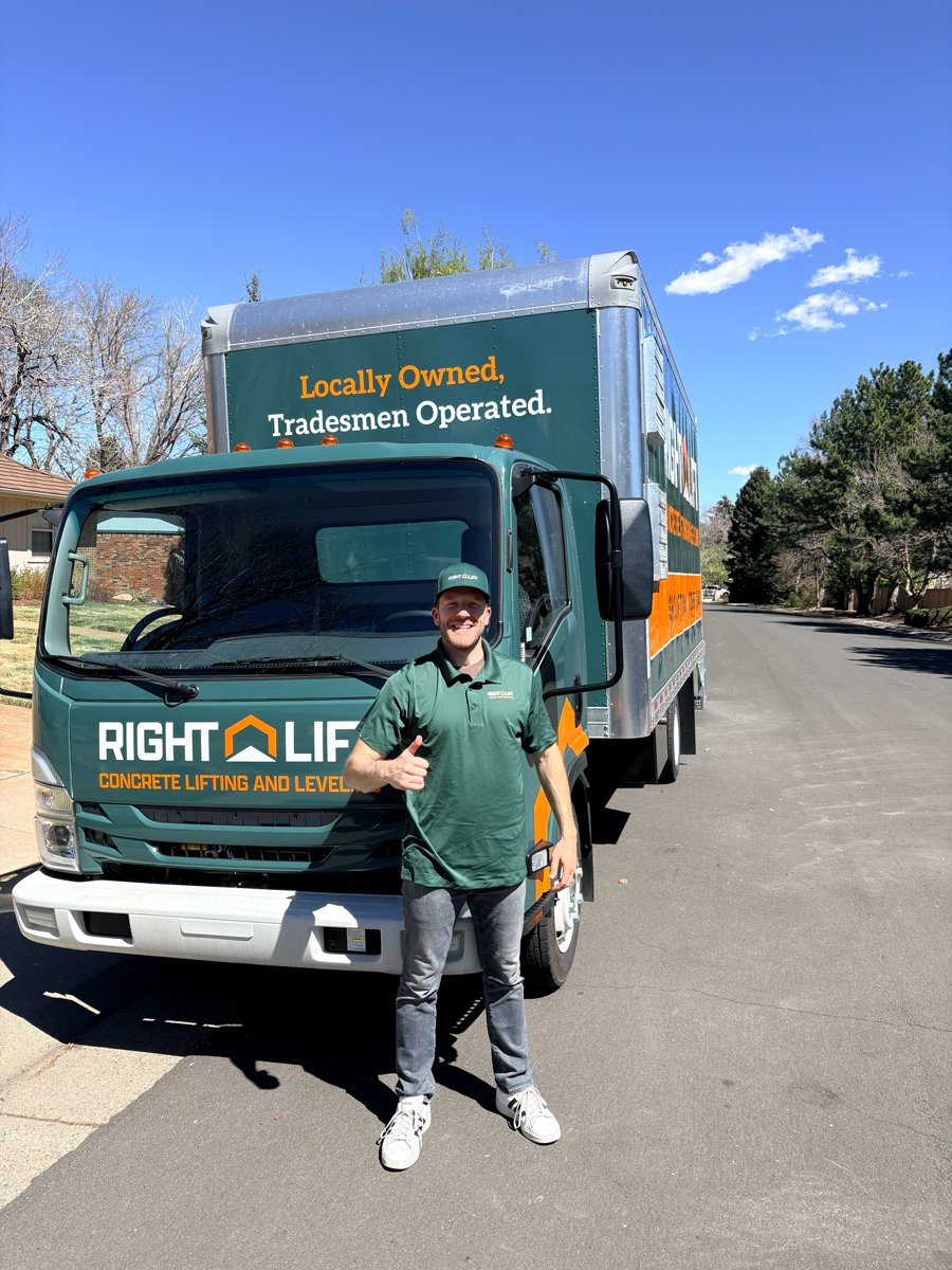 Rightlift tradesmen giving thumbs up in front of RightLift concrete lifting truck on sunny street.