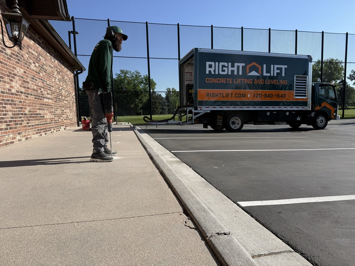Rightlift tradesmen using a drill on concrete near a truck labeled RIGHTLIFT for concrete lifting and leveling.