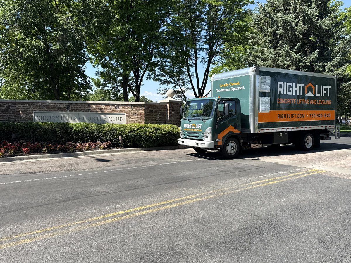 RightLift truck parked near Cherry Hills Country Club sign with trees and bushes in background.