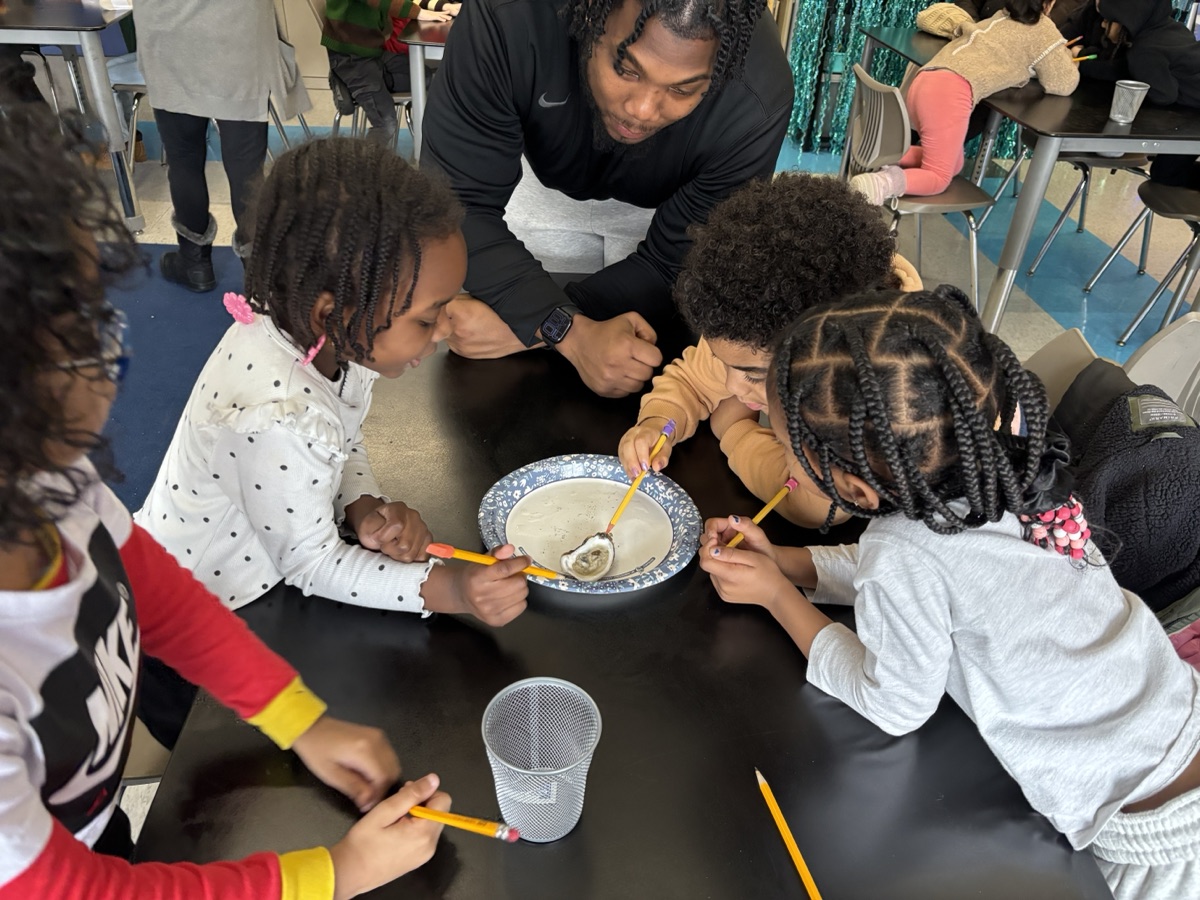 Students examine an oyster together during a classroom workshop