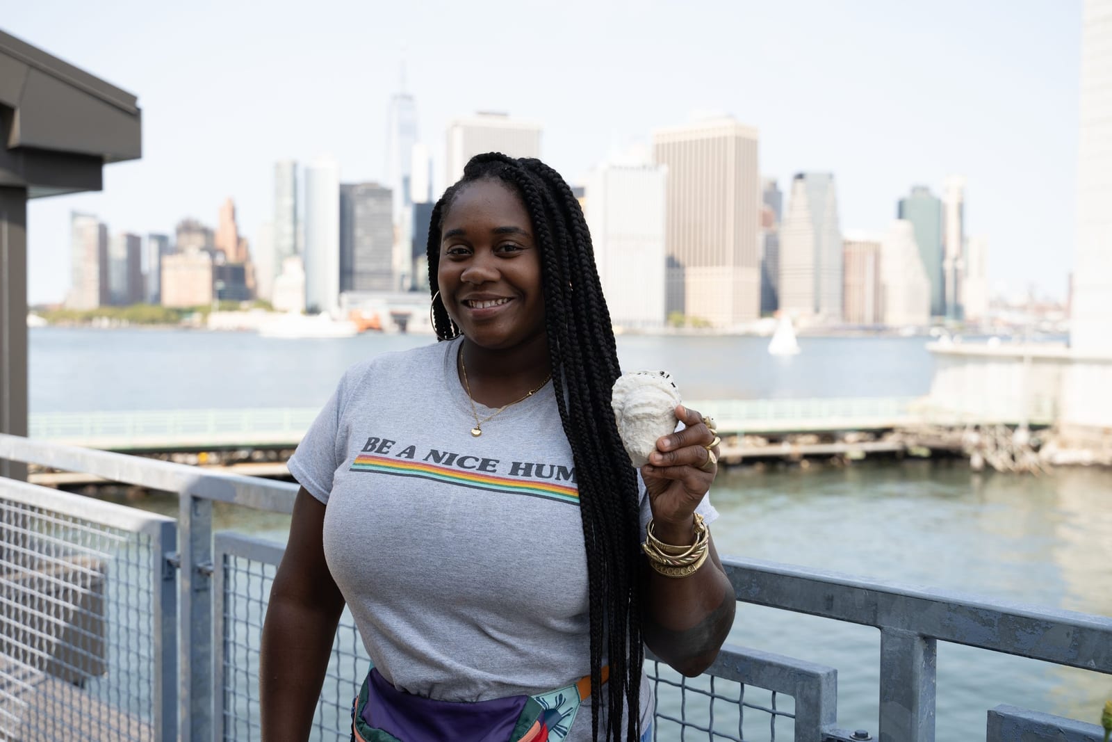 A program participant holds a small sample with the Manhattan skyline behind her
