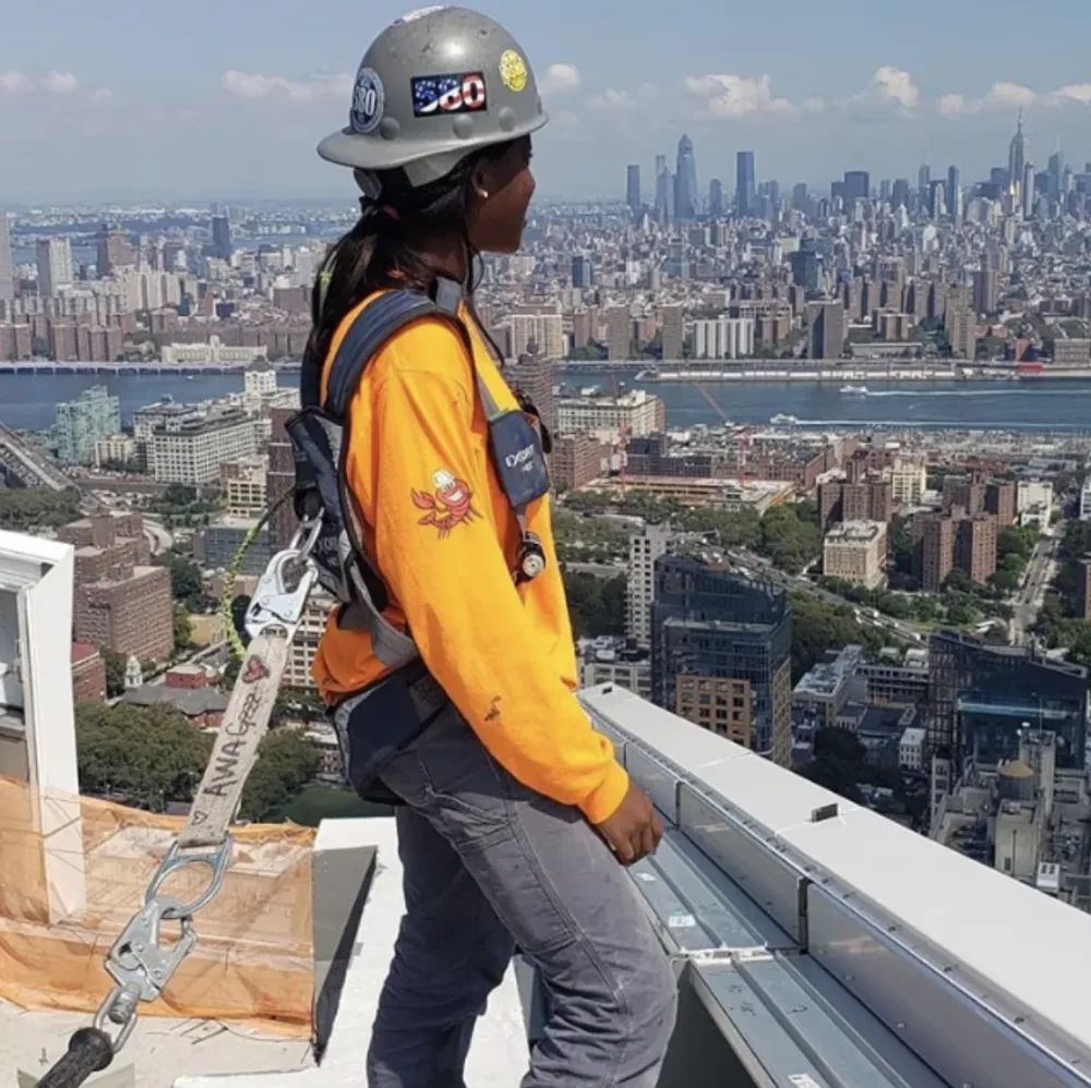 Awa Sylla works in safety gear on a high-rise construction site