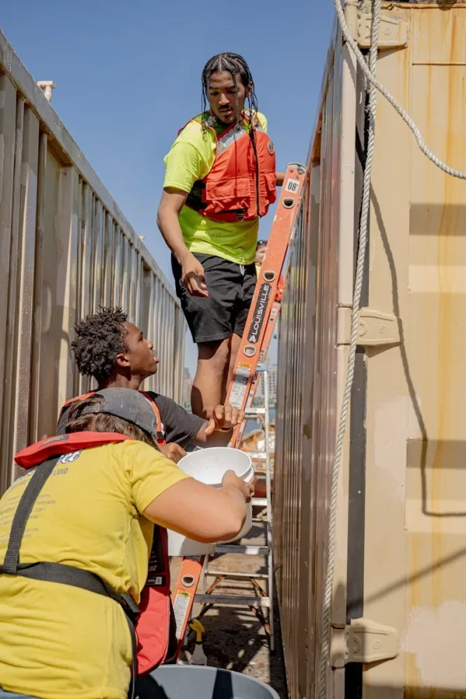 Ray Rivera adds oyster larvae to retrofitted shipping containers at Pier 101 on Governors Island.