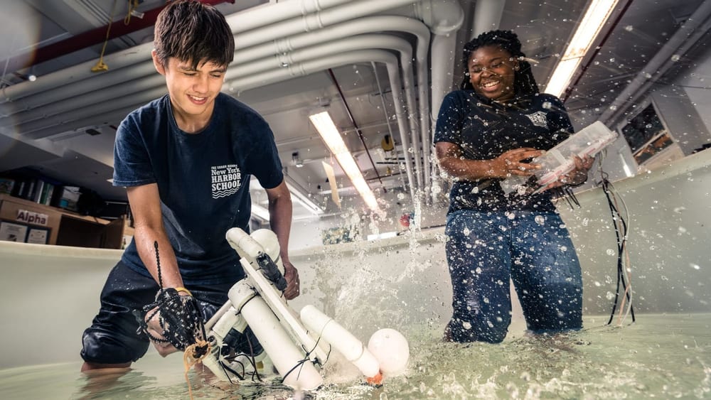 A worker sprays water while a colleague watches inside a restoration facility
