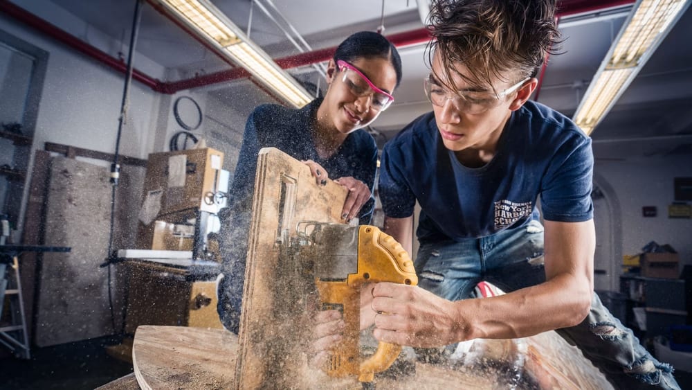 Students build a wooden structure in a workshop